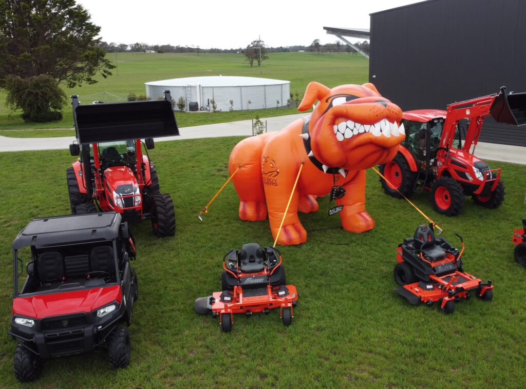 surrounded by a green field is a selection of tractors and mowers for ACF Equipment's opening day. 
